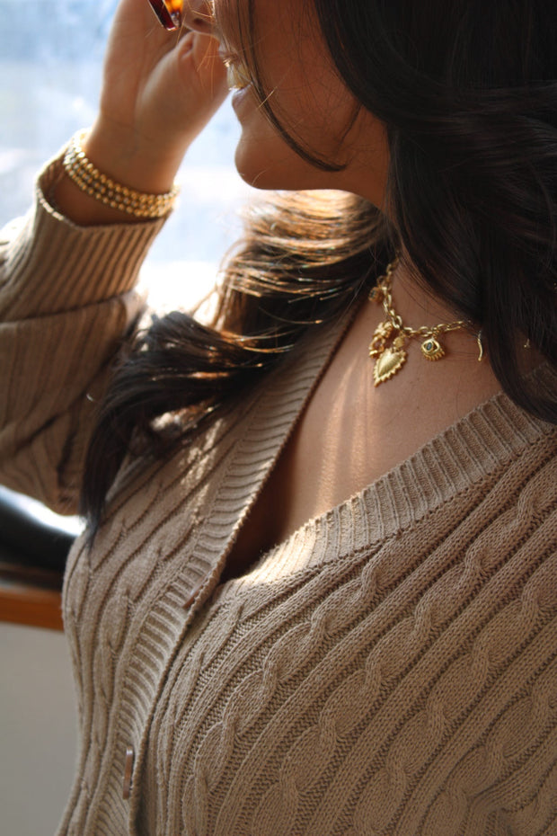 Woman wearing several bead bracelets and charm necklace.